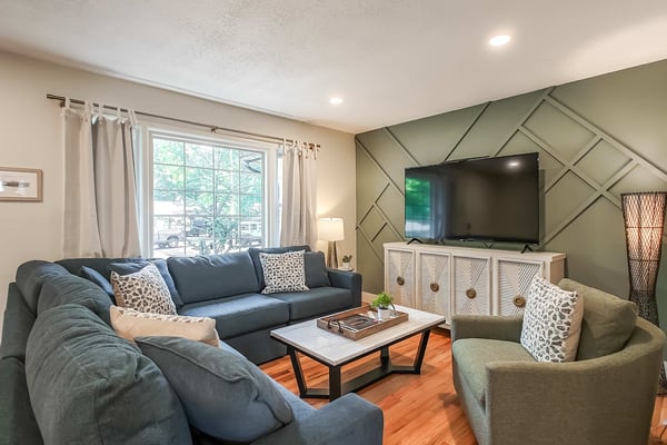 Modern kitchen with white cabinets, stainless steel appliances, white subway tile backsplash, and wood countertops.