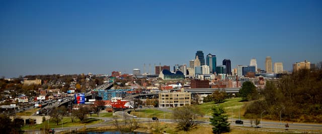Kansas City skyline viewed from a park with a small lake in the foreground